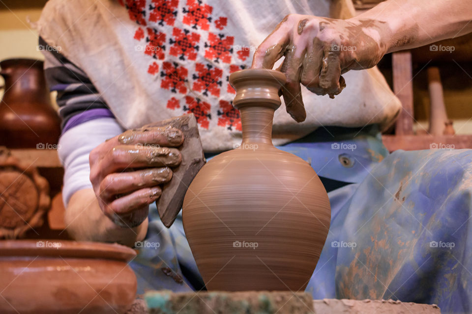 Learning pottery - man making a pot of clay