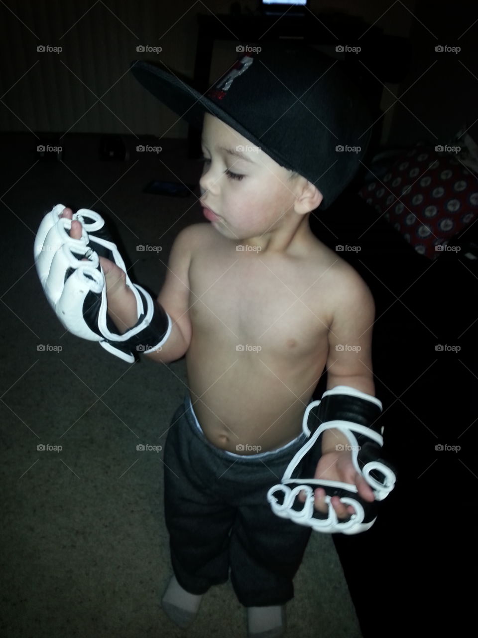 little MMA fighter. my son trying on my MMA gloves