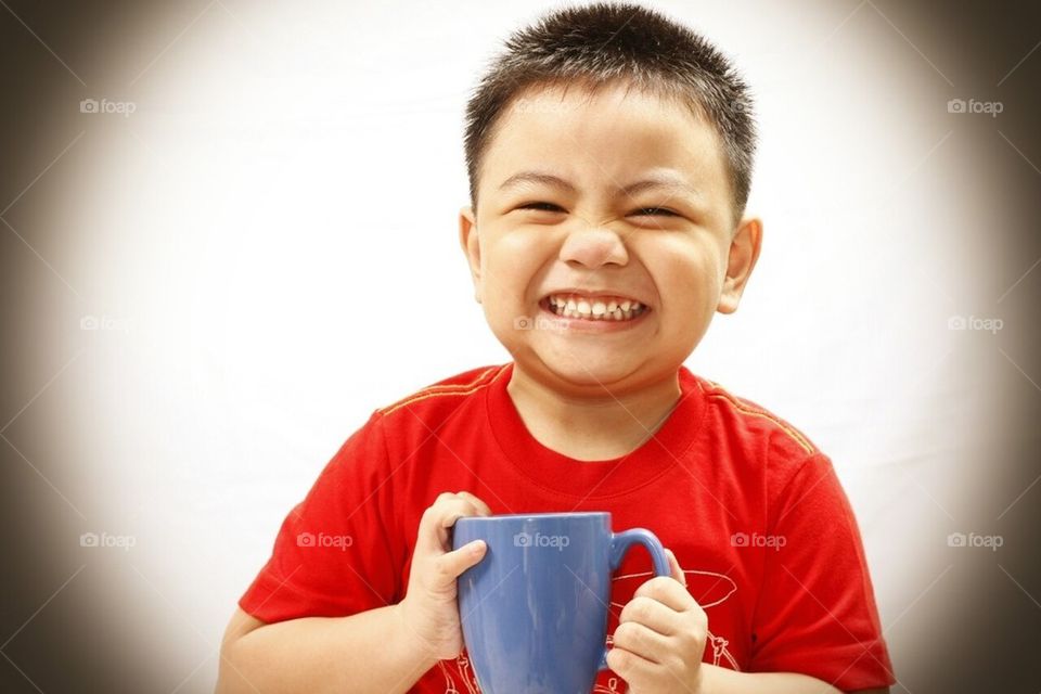 Child smiling and holding mug