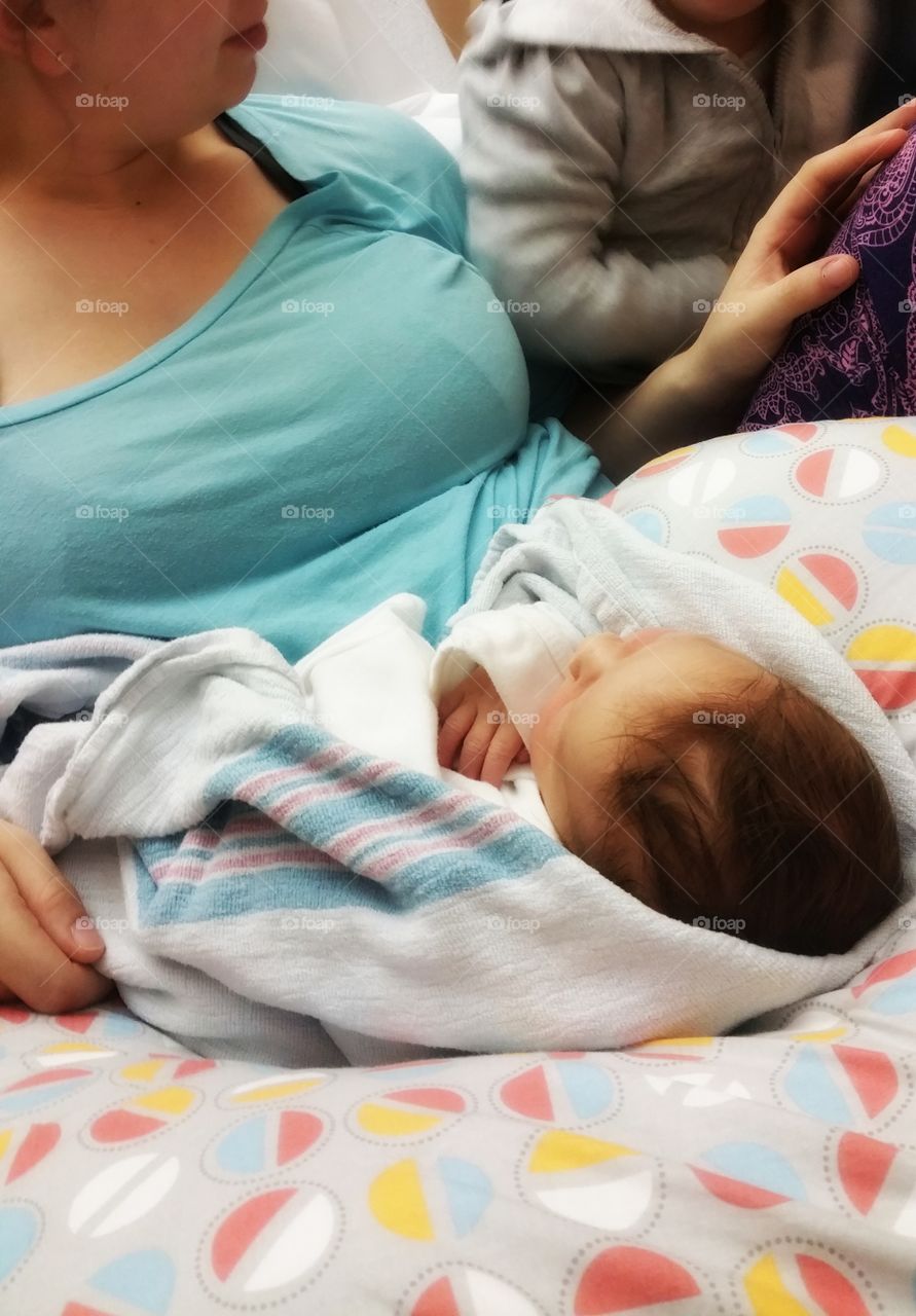 Newborn in hospital bed with mom