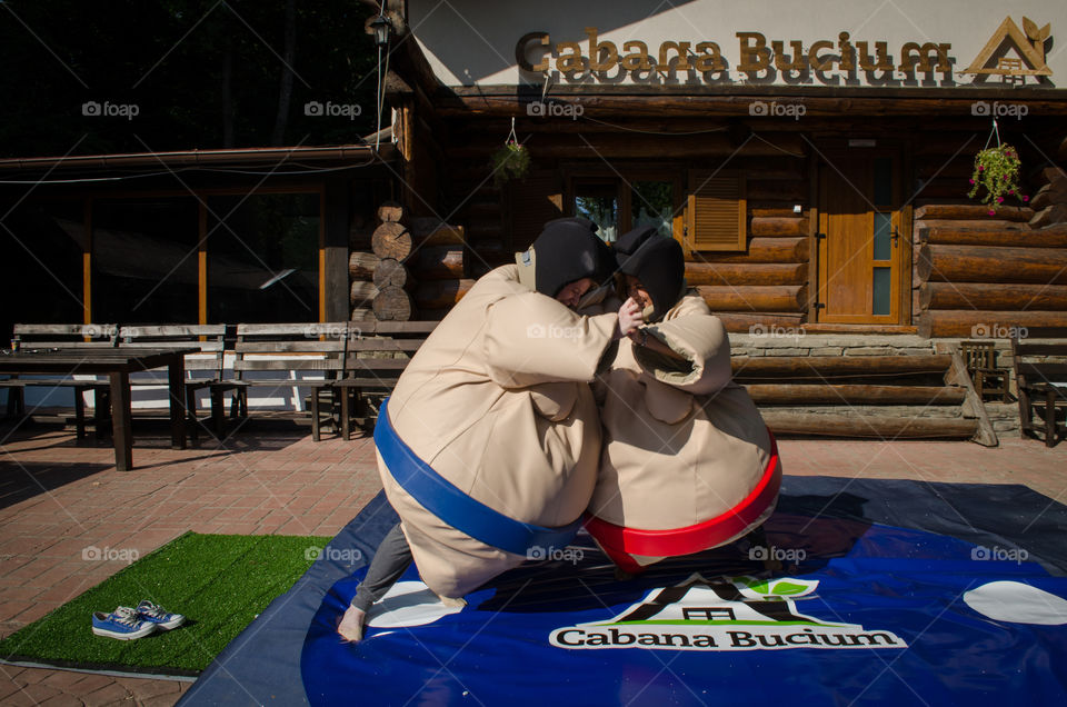 adults having fun in sumo costumes