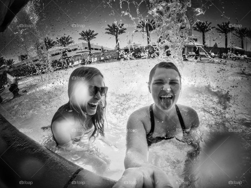 Female friends enjoying in swimming pool at resort