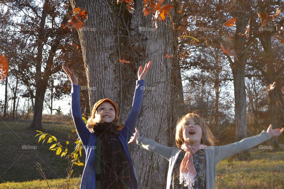 Girls Throwing Autumn Leaves in the Air
