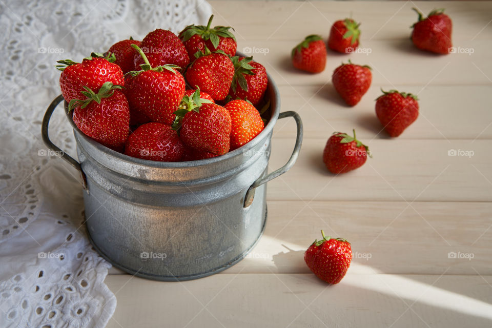 A vintage pail full of freshly picked strawberries 