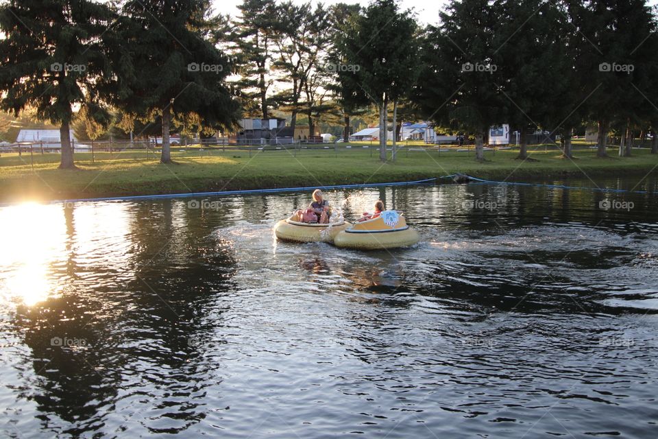 Kids having fun riding in bumper boats in summertime