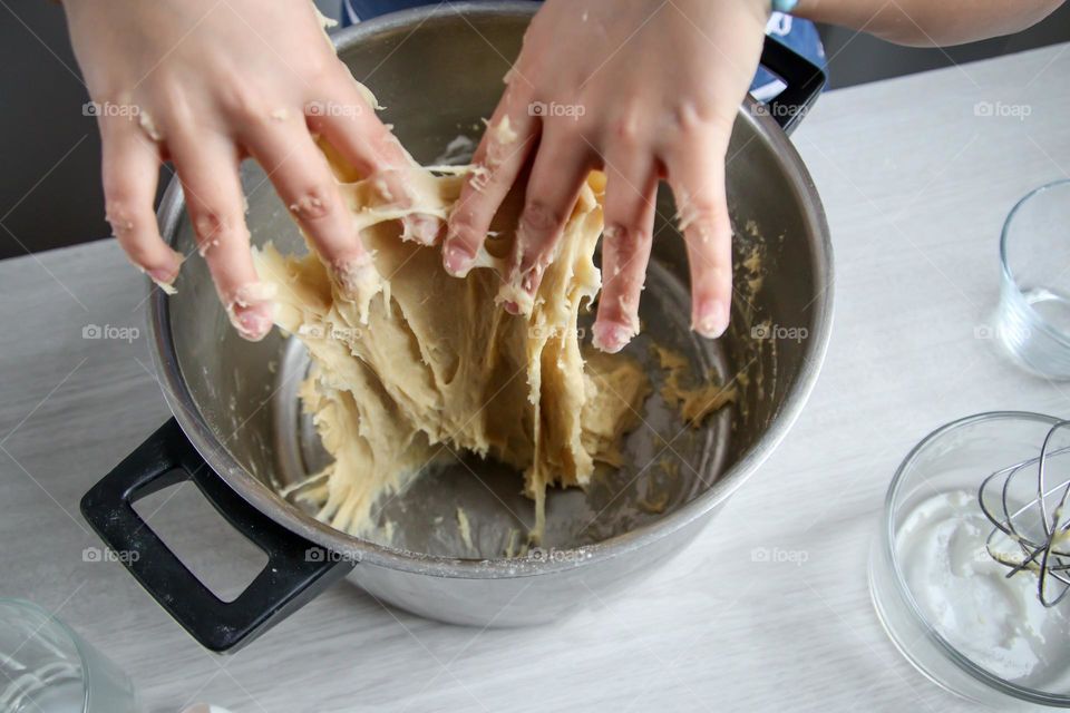 Child is mixing a bread dough