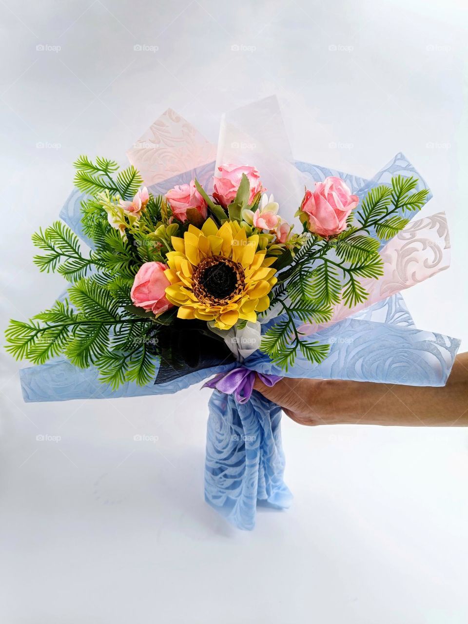 A bouquet of artificial flowers on white background.