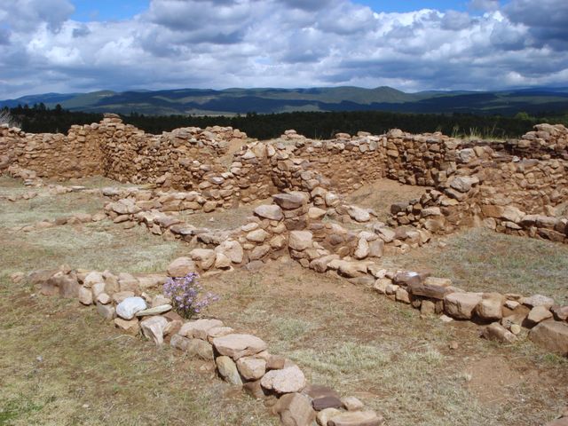 Ruins of Pecos pueblo with rolling hills beyond 