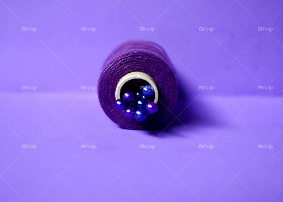 Spool of theard against purple background