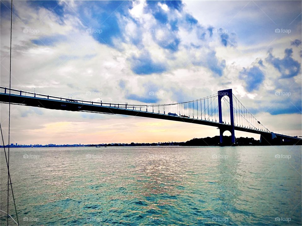 The Throgs Neck Bridge leads across the East River in the upper parts of Queens, NY. We sailed our new boat southbound home to Newtown Creek in Long Island City in the evening hours as the sun is about to set. August 2017. Hypnotic Productions