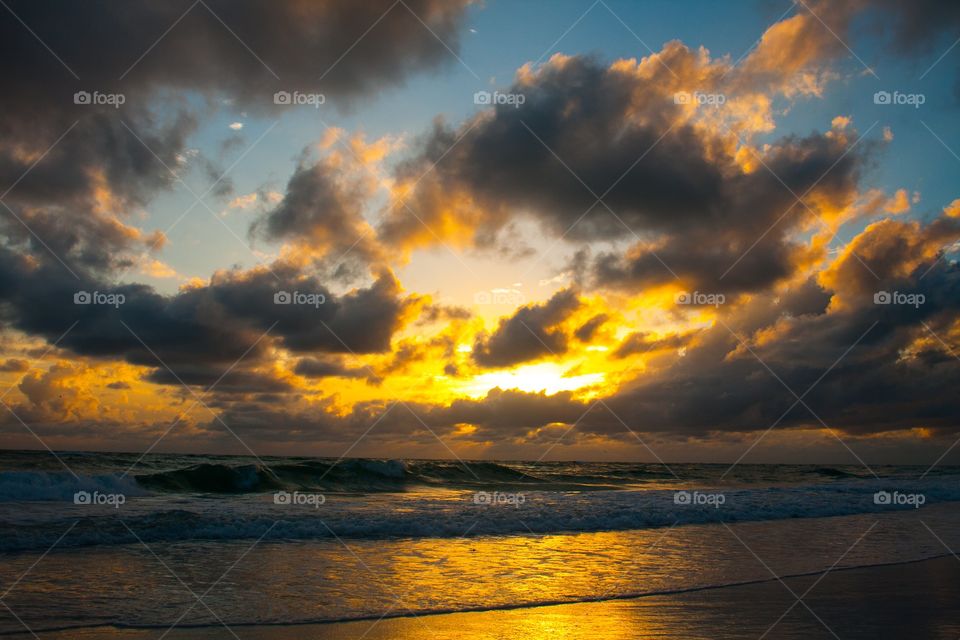 Yellow sunset over cloudy ocean