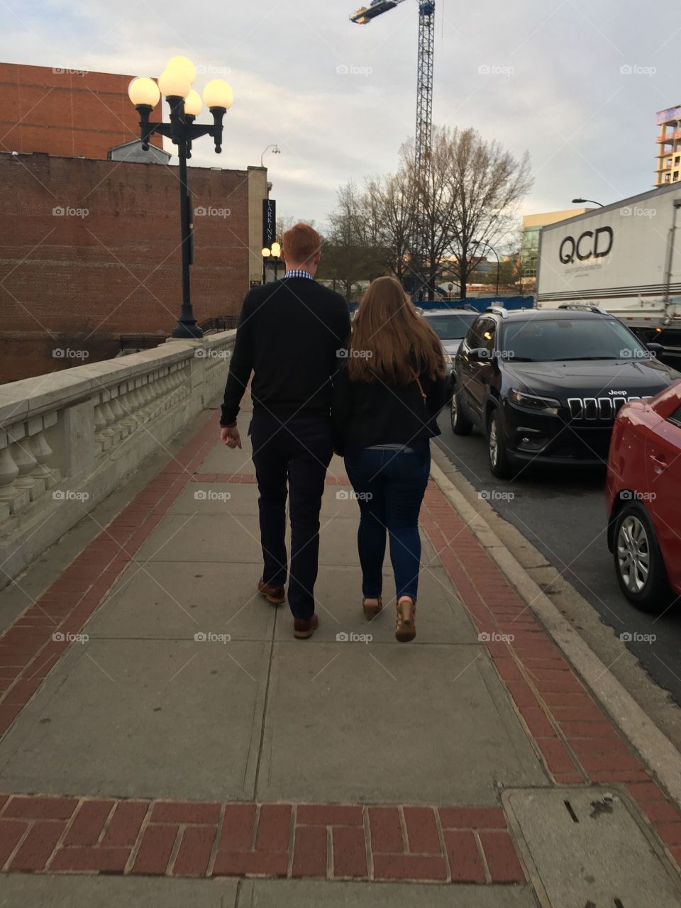 Couple walking downtown Greenville holding hands 