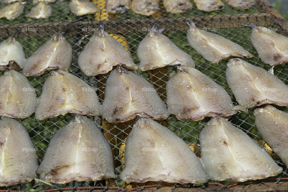 Dried salted fish in the sun On bamboo basket.