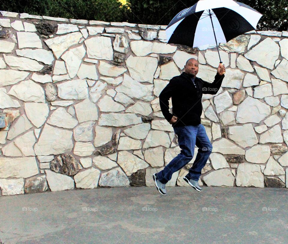 umbrella. Man. person. jumping. photography. black and white. a man jumping while holding an umbrella.