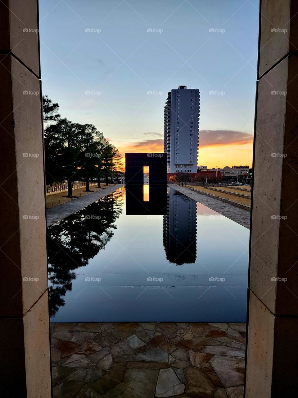 Peering through a doorway of the Oklahoma City memorial of the 1995 federal building Bombing across the reflecting pond to the other gateway