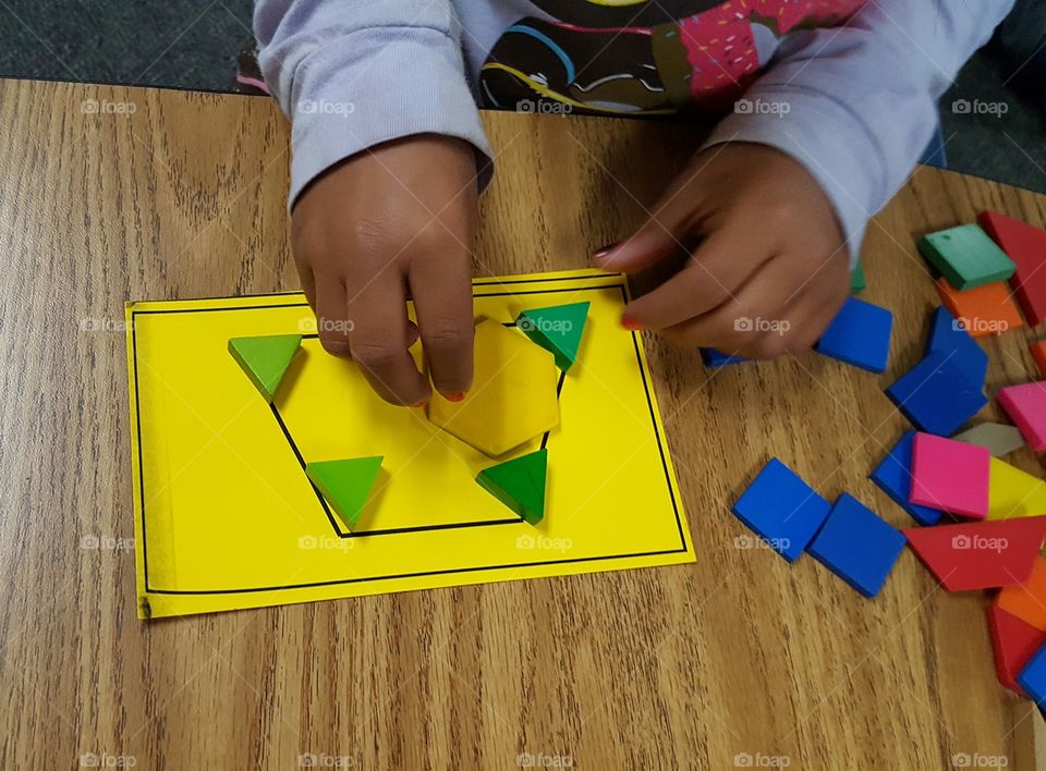 Child using pattern blocks to learn about shapes