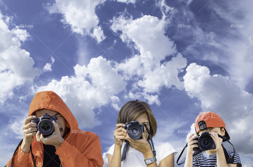 Hand man , woman and boy holding the camera Taking pictures  The background sky and clouds