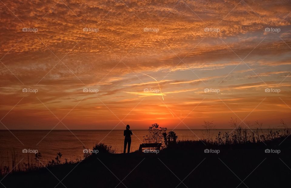 Silhouette of people standing near lake