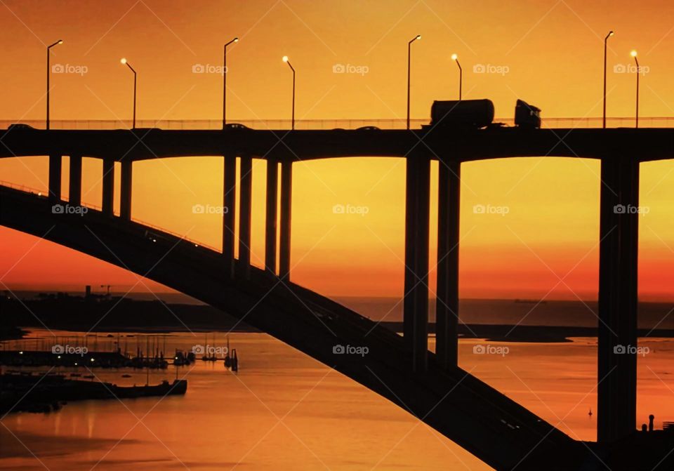 Sunset as evening traffic crosses a road bridge over the Rio Douro in Porto