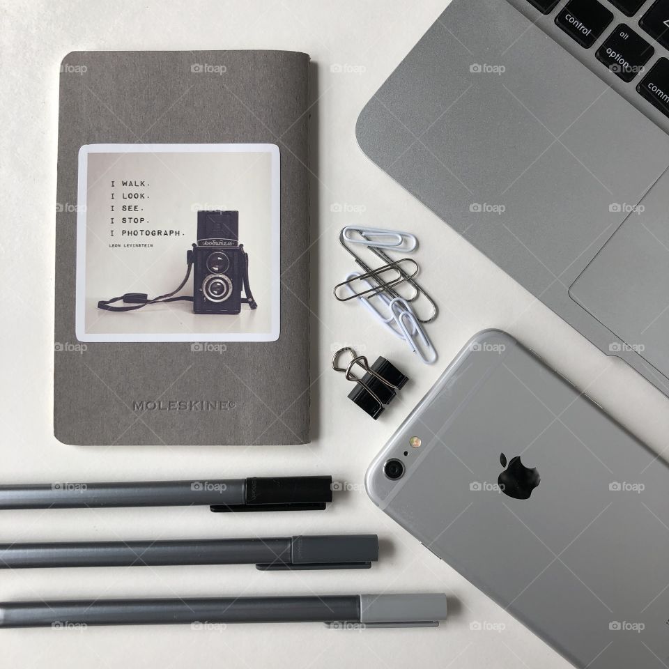 Gray, and black and white flat lay with office supplies, technology and a notebook for a photographer