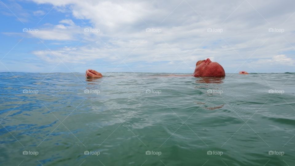 Man floating on sea