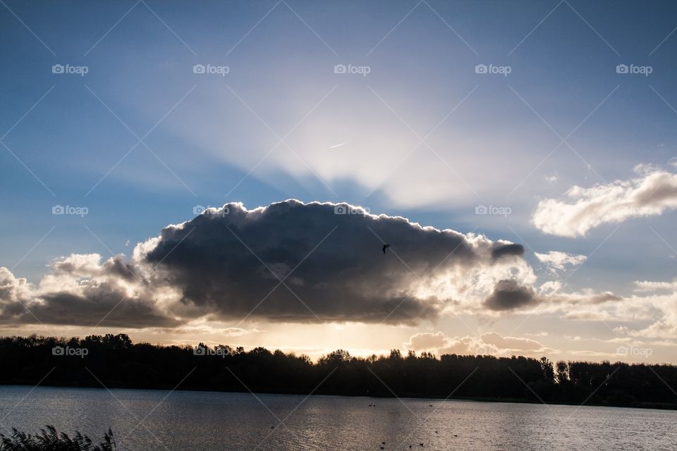 A beautiful morning in the park with a little bit fog and sun rays behind the clouds 