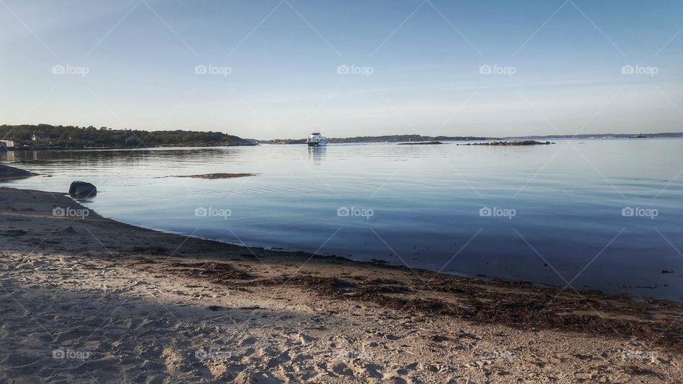 Ferry, calm sea, beach, evening