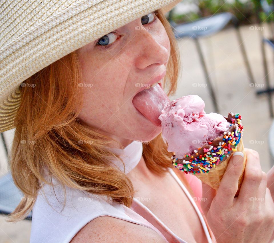 Young woman enjoying ice cream in the park on a sunny spring day!
