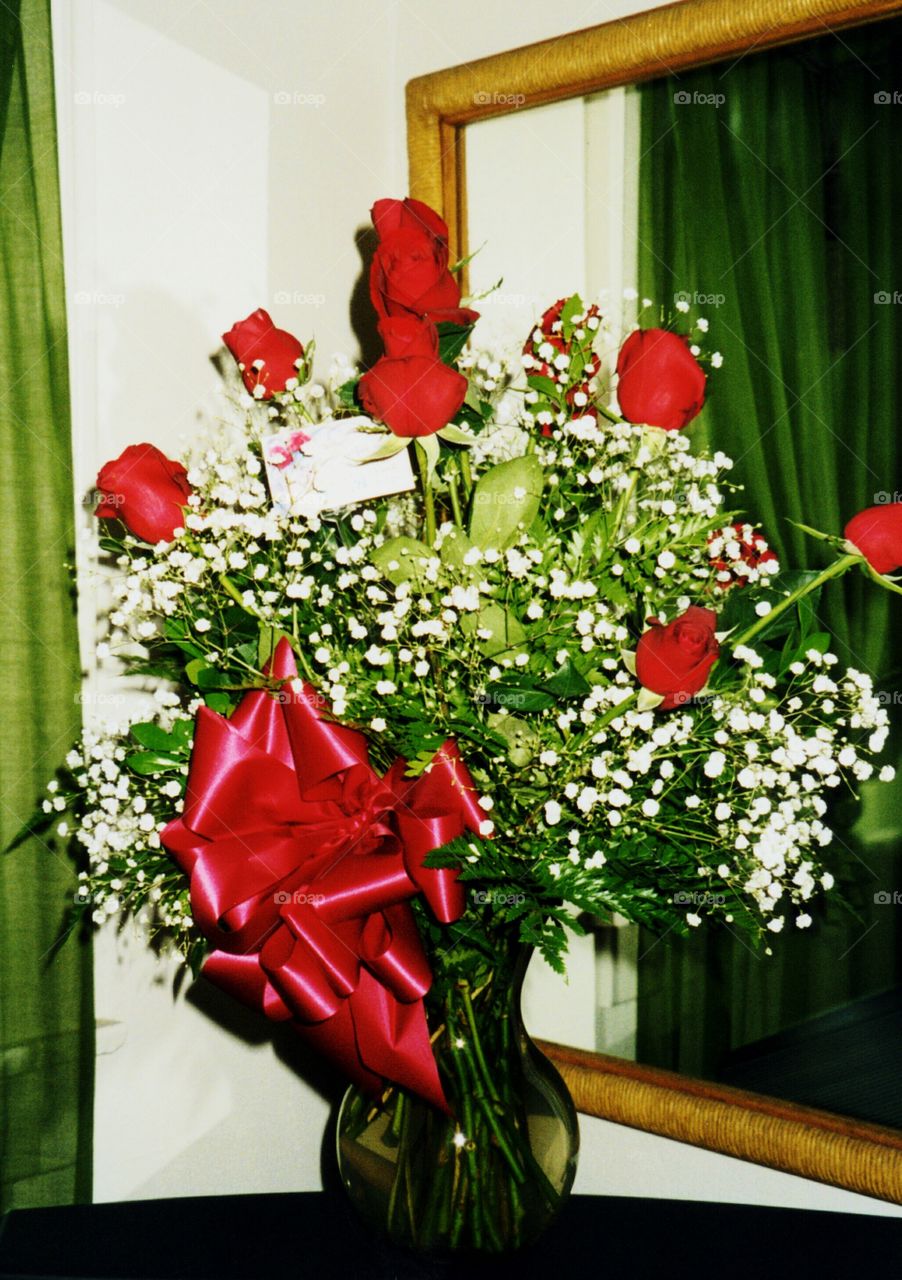 red roses and baby's breath. red rose and white baby's breath floral arrangement with big red bow