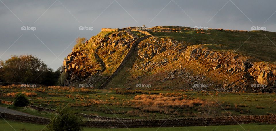 Hadrians wall on field against sky