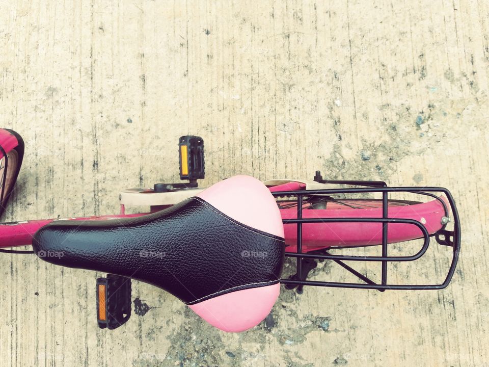 pink and black bike on cement floor