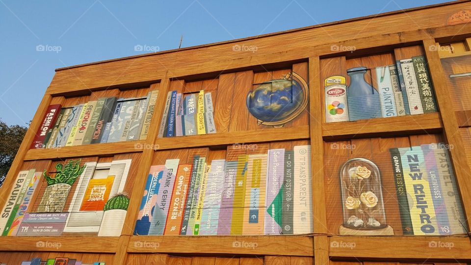 There are murals on the building, the murals are images of bookshelves