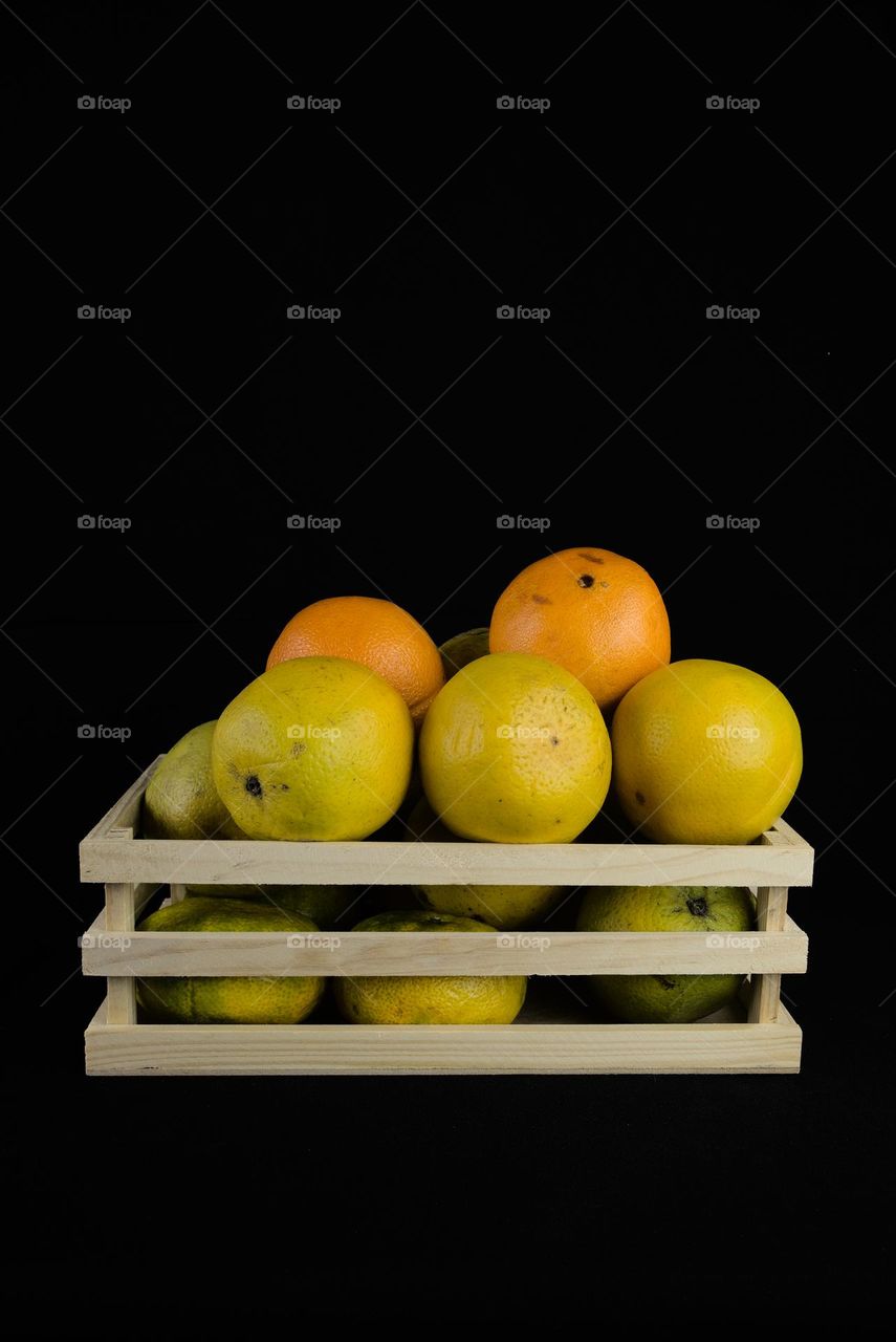 Fruit box with oranges on black background