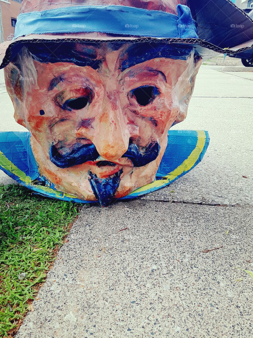 A discarded paper mache head of a man that was put to the curb.