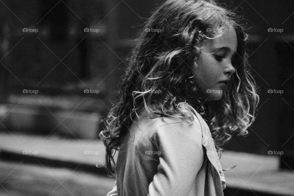 Beautiful little girl looking at the ground 