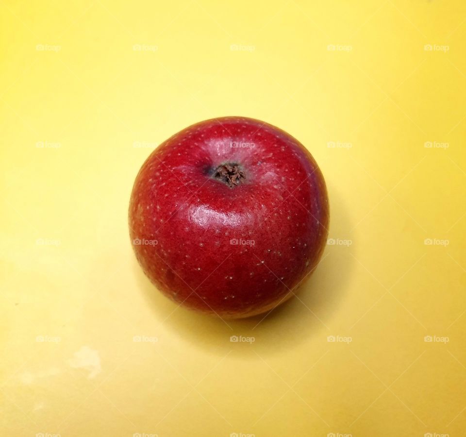 red apple on a yellow background