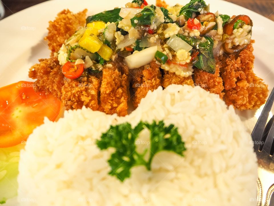 Thai spicy food heart shape rice topped with fried pork and basil