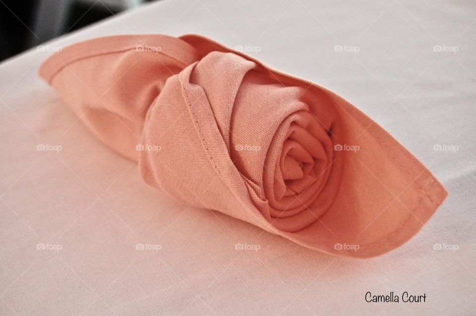 Perfectly round peach colored cotton napkin at a wedding