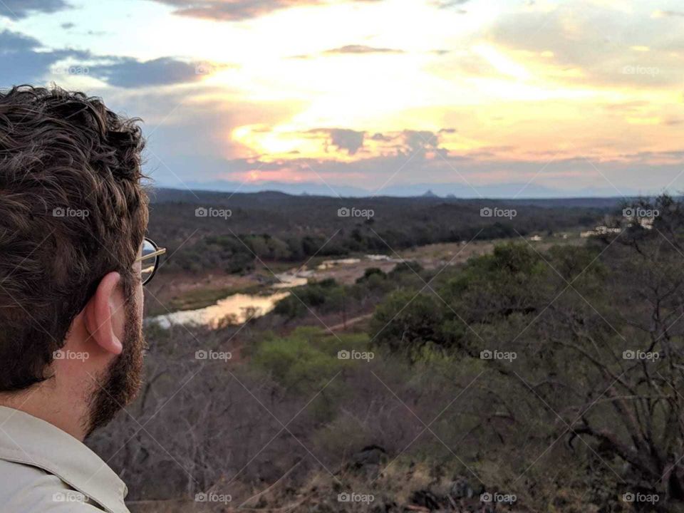 Man looking out over river in Kruger National park