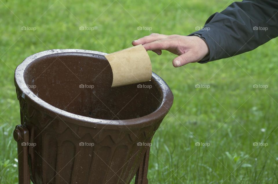 man throws away paper cup