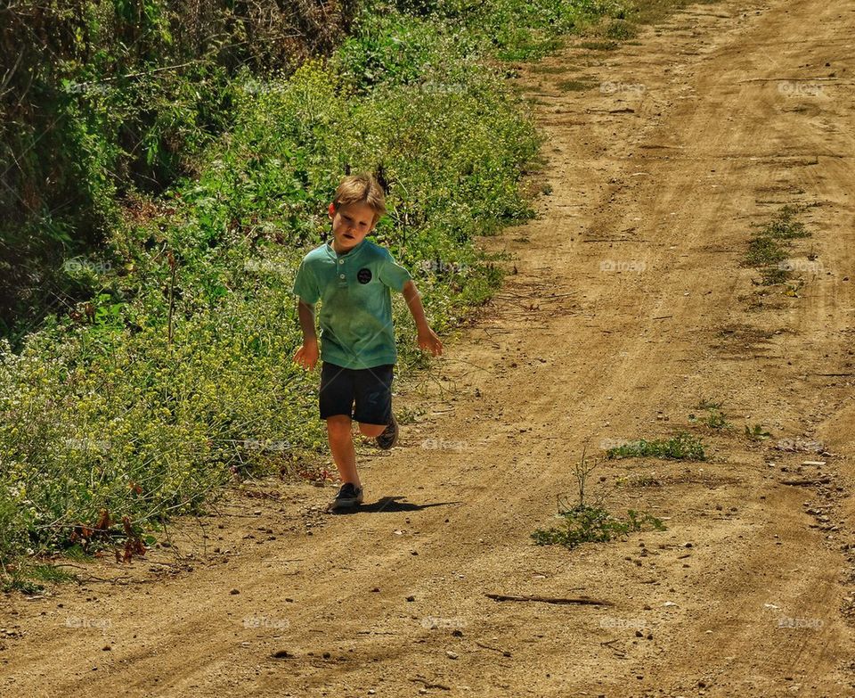 Boy Running Down A Country Road