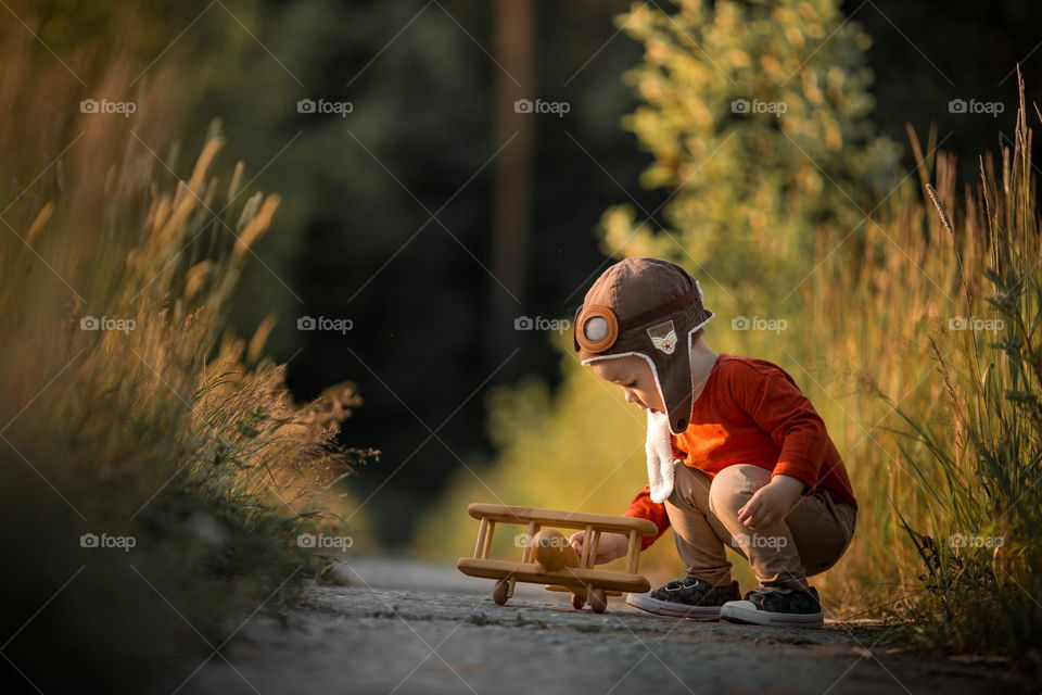 Mother and son with wooden plane at sunset