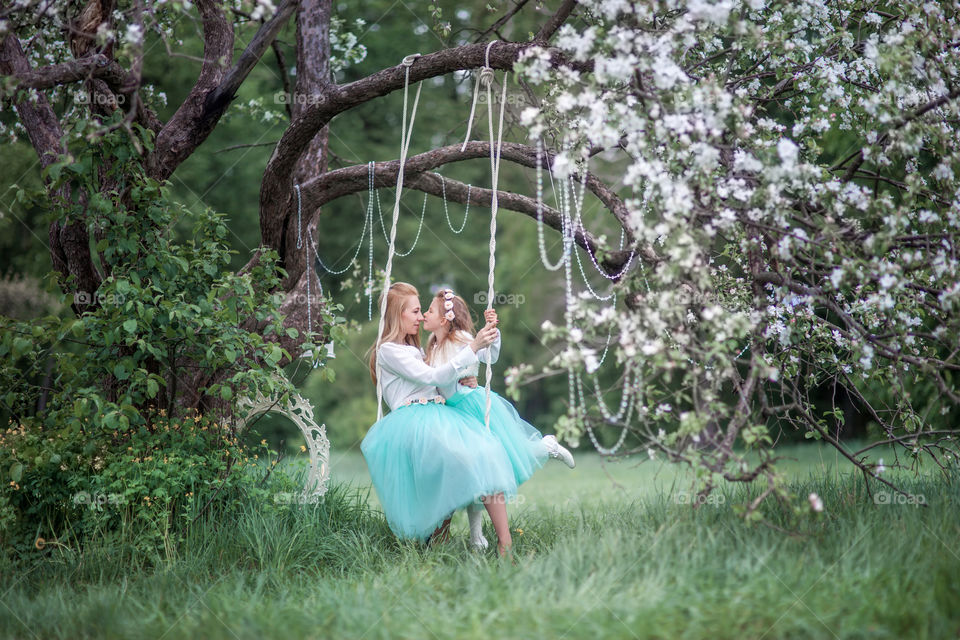 Little girl with mother in a blossom park