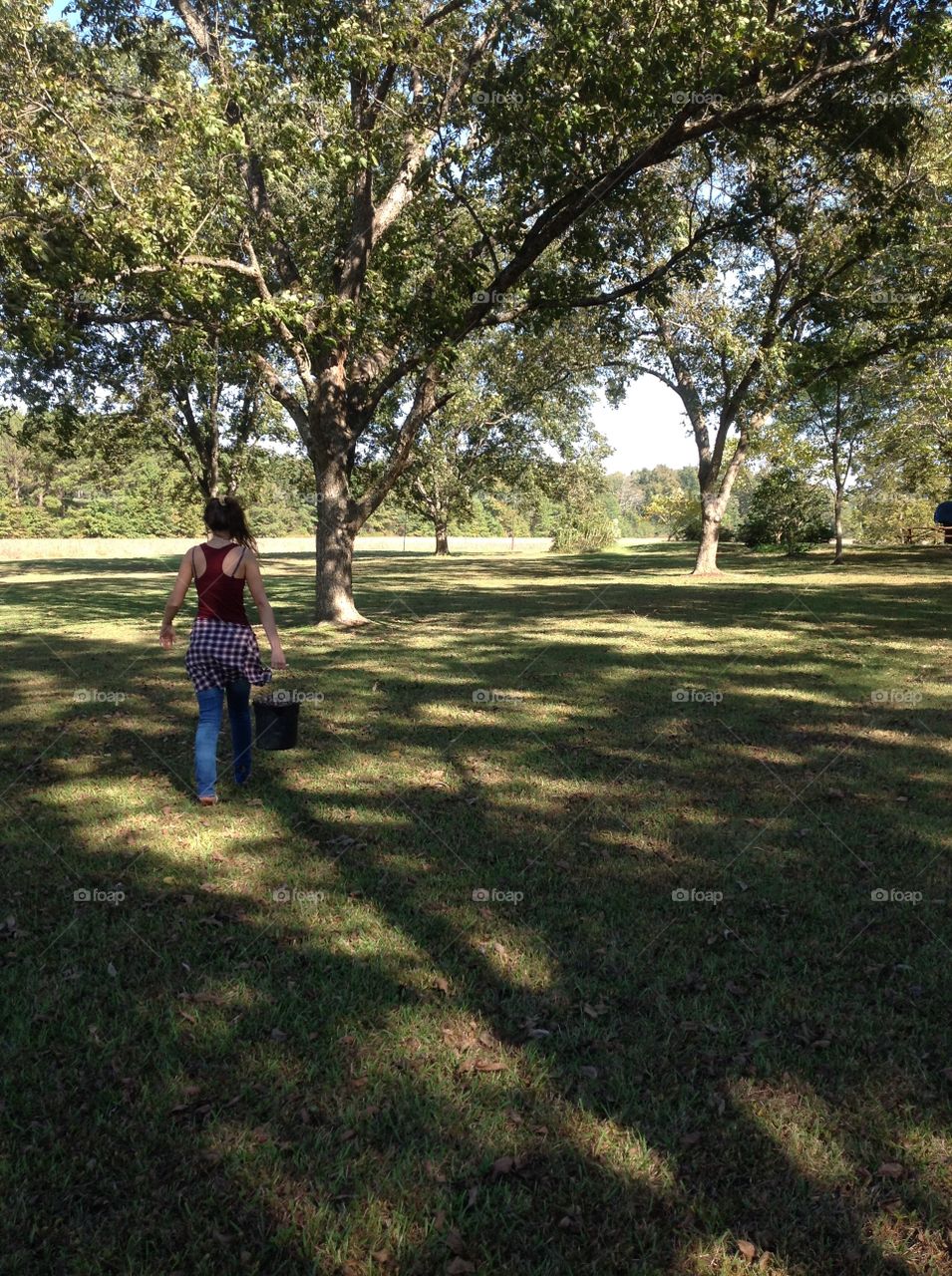 Girl walking with bucket full of pecans