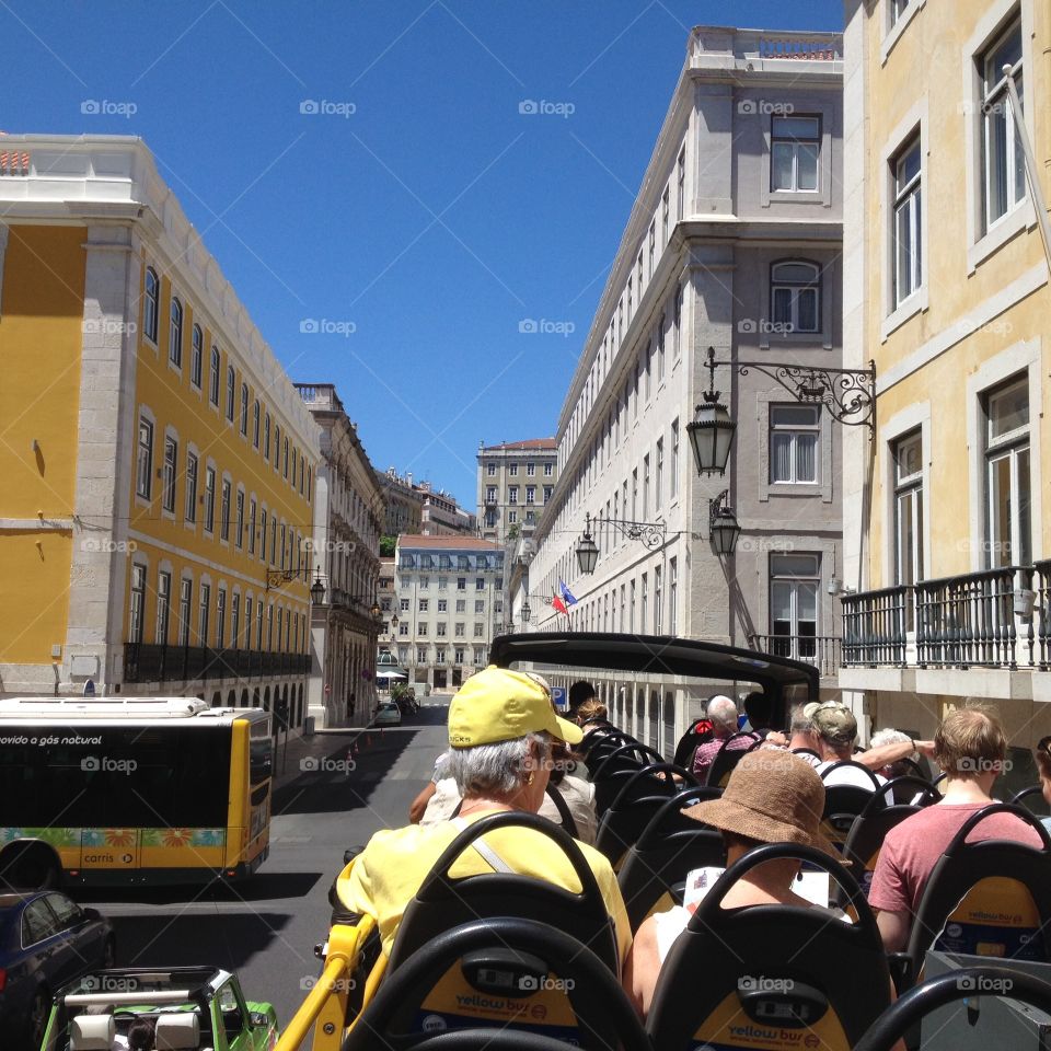 View from tour bus in Lisbon. View of tourists and the city from an open top tour bus in sunny Lisbon