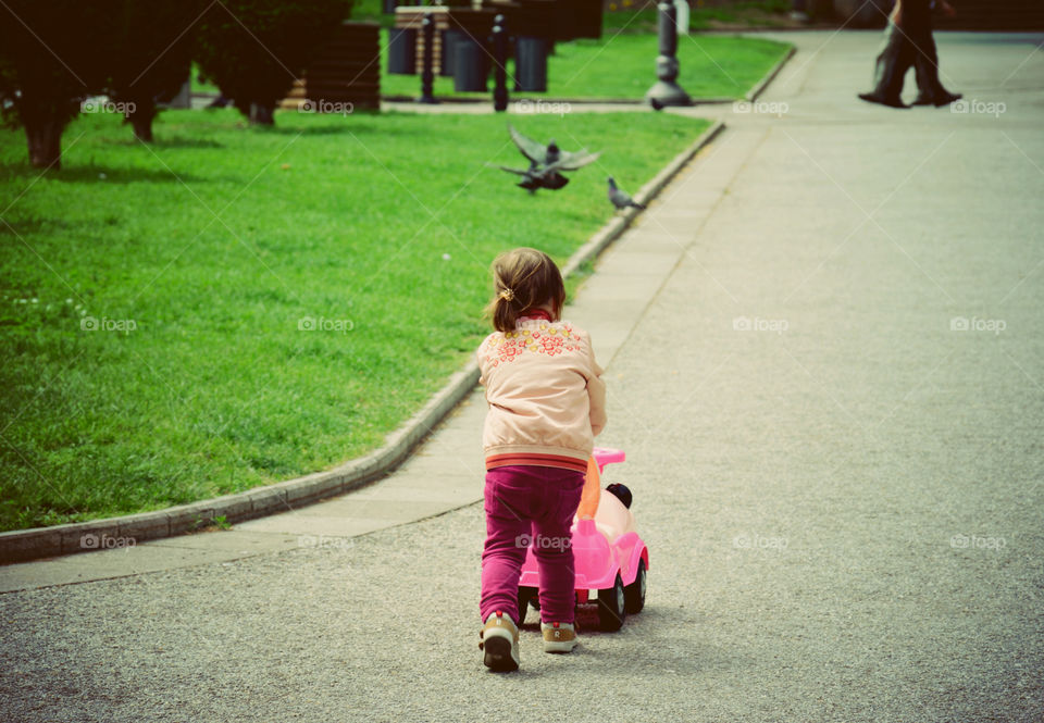 Little girl with toy car in park