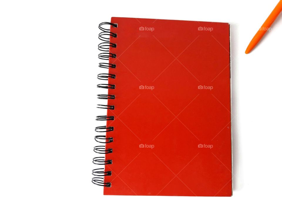 red notebook with orange pen isolated on white background