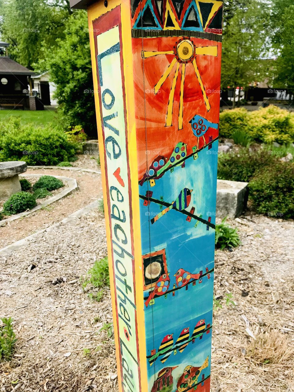 Gorgeous colorful bright totem pole discovered in beautiful garden area full of flowers! 