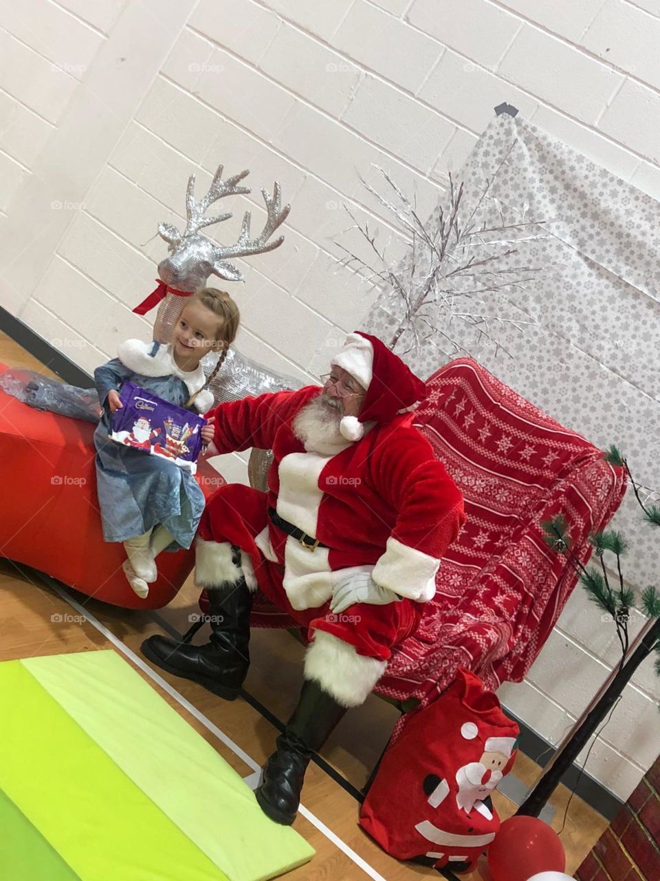 Little girl meets Father Christmas at her Gymnastics club