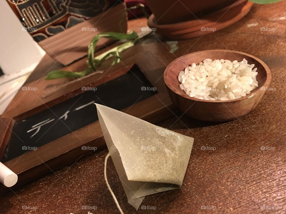 Preparing Green tea with rice in bowl and triangle Japanese tea bag on table with  chalkboard with writing "tea" 